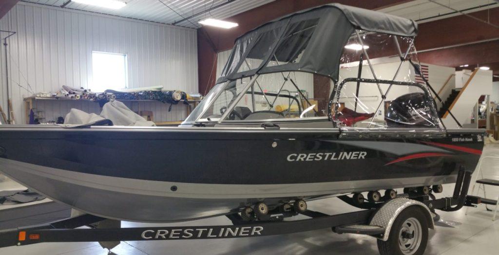 Crestliner boat with black and clear canopy.