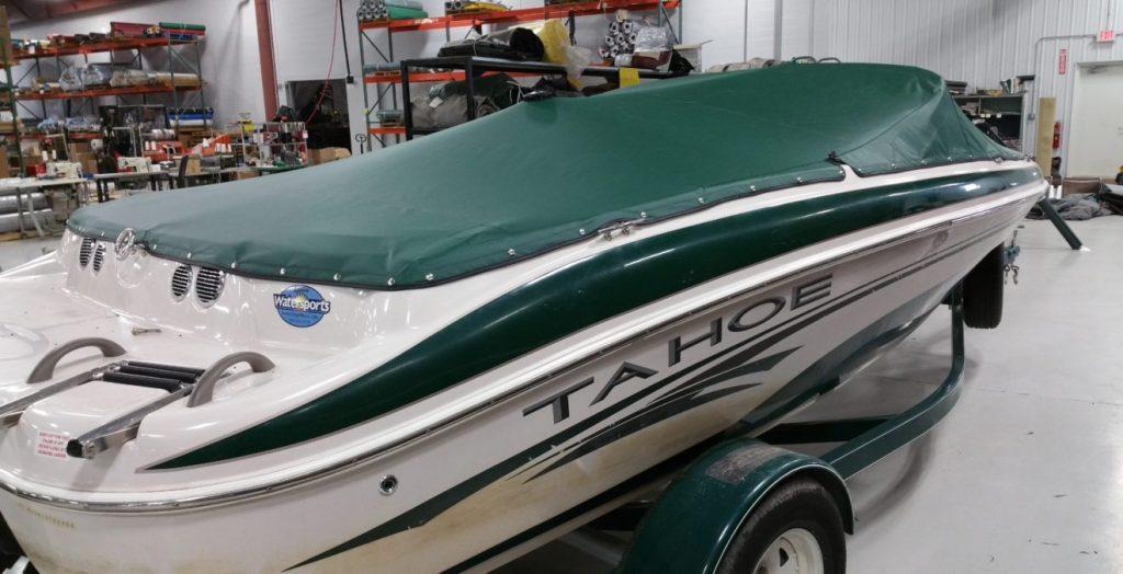 Green and white Tahoe boat with green cover.