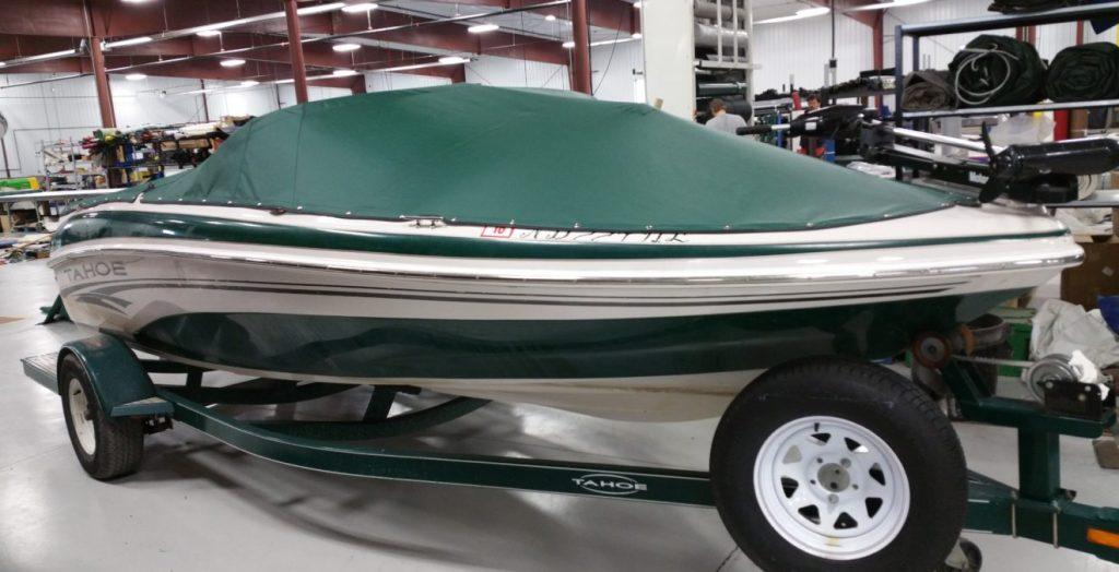 Green and white Tahoe boat with green cover.