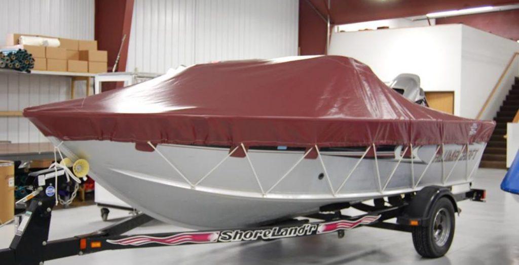 White Alumacraft boat with maroon cover.