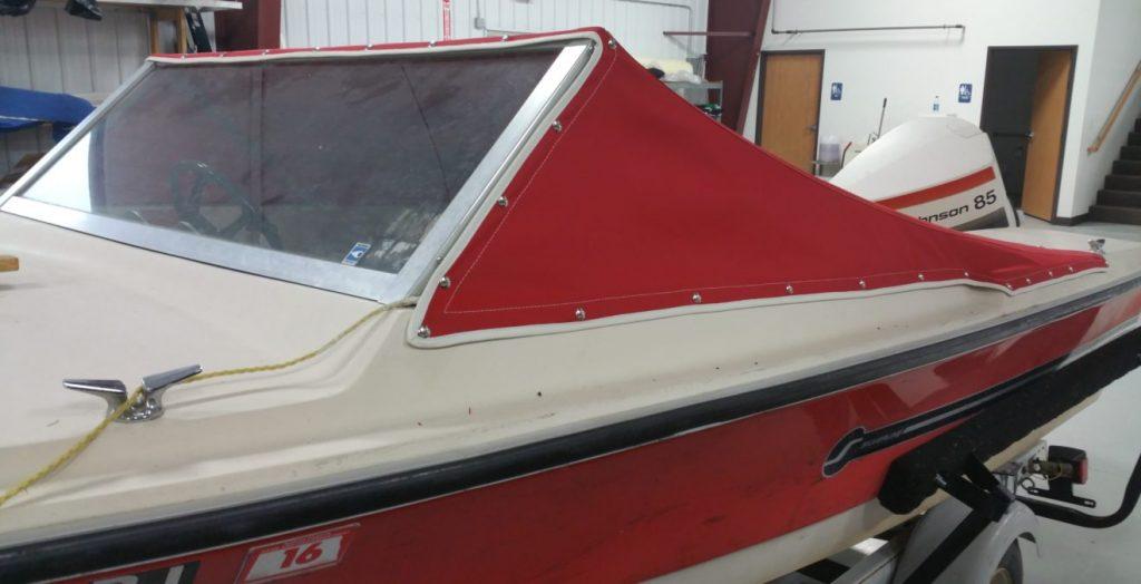 Red and white boat with red cover.