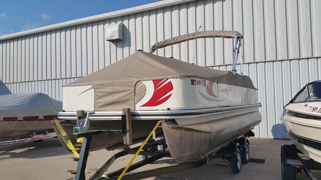 Suncruiser pontoon with tan cover in front of T.R.S. Industries.