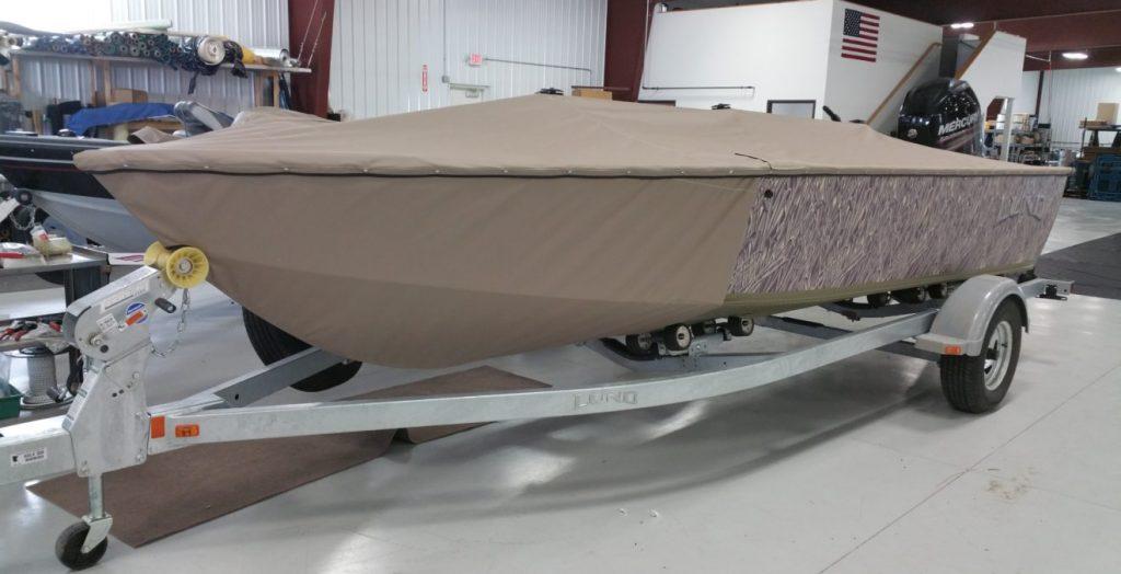 Camouflage boat with tan cover.