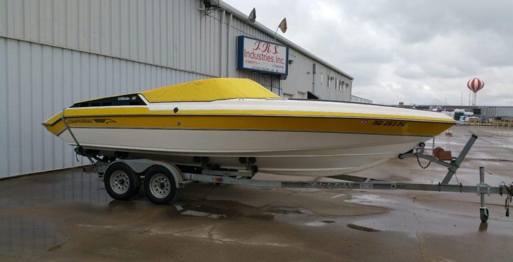 Yellow and white Chaparral boat with yellow cover in front of T.R.S. Industries.