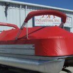 Suncruiser pontoon with red cover in front of T.R.S. Industries.