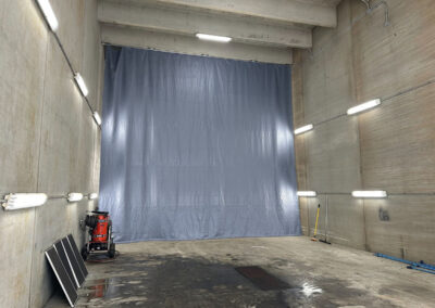 Ceiling-mounted curtain enclosure installed in a wash bay area
