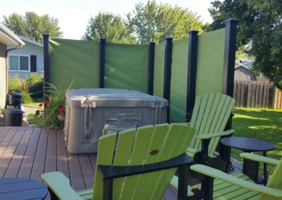 Bright green custom outdoor fabric privacy screen installed around a patio deck and hot tub.