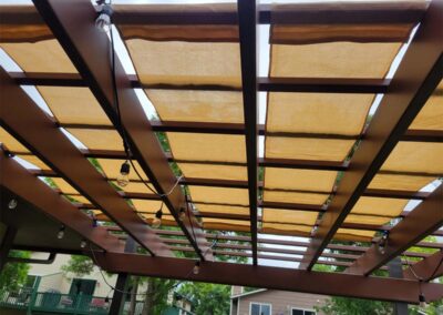Pergola shade tarp system installed over an outdoor living area