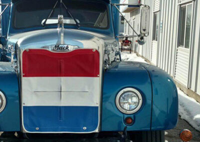Custom red, white, and blue vinyl winter front installed on a commercial truck