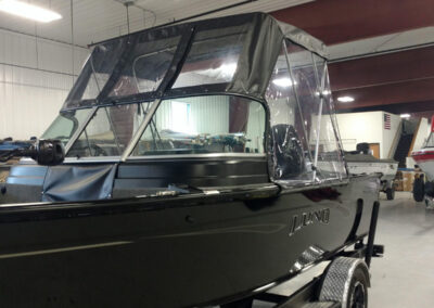 High-angle shot of a sleek black marine canvas bimini top and custom clear vinyl window panels.