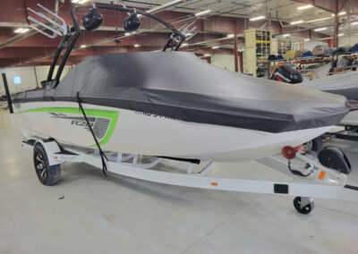 Profile perspective of a boat on a trailer wrapped tightly in a heavy-duty black custom marine canvas cover.