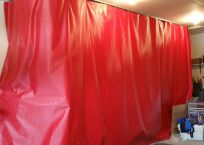 Red industrial curtain mounted on a ceiling track system