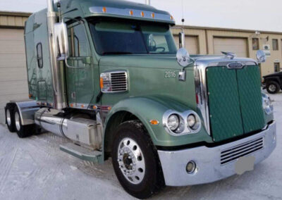 Colored quilted winter front cover installed on a semi-truck