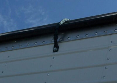 Trailer tarp securing accessory system installed on hauling equipment