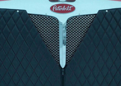 Black vinyl, quilted winter front installed on a commercial semi-truck