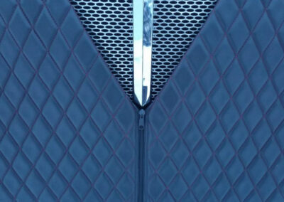 Blue vinyl, quilted winter front installed on a commercial semi-truck