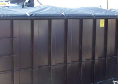 Construction refuse tarp system installed on a hauling trailer