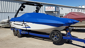 custom-boat-marine-canvas-covers A blue custom marine canvas boat cover enclosing a sports powerboat on a boat trailer.