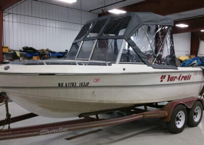 Elevated view looking down at a dark gray custom canvas bimini top installed on a boat inside a facility.