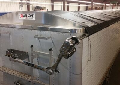 Electric roll tarp system mounted on a hauling trailer