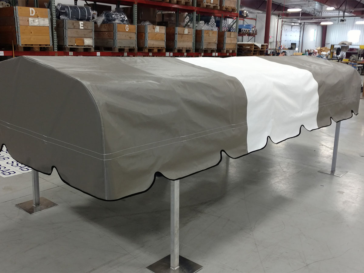 burgundy-bimini-top-with-clear-windshield Side view of a burgundy marine canvas bimini top integrated with a clear vinyl front windshield panel.