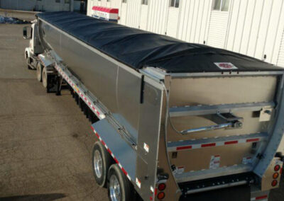 Trailer roll tarp system protecting transported materials
