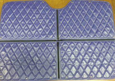 Purple, quilted insulated winter front mounted on a semi-truck