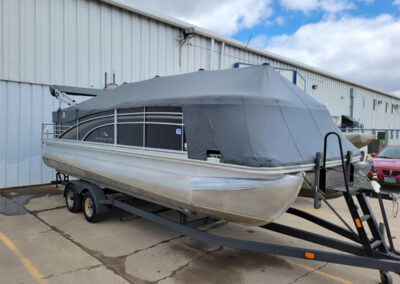 Light gray playpen style mooring cover secured on a pontoon boat.