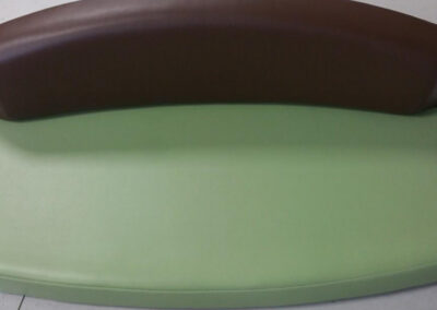Upholstered marine bench seating with brown back and green upholstery for a boat interior