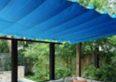 Outdoor shade tarp installation providing coverage over an exterior space