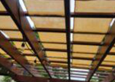 Pergola shade tarp system installed over an outdoor living area