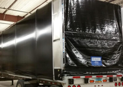 Accordion-style retractable Conestoga tarp system on a flatbed trailer