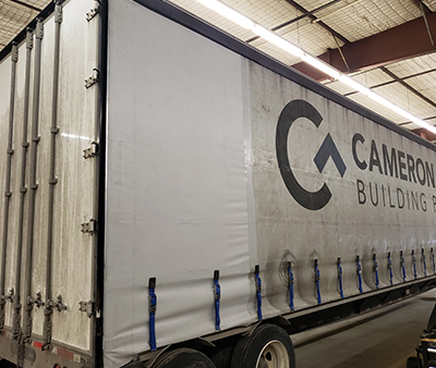 pontoon-boat-marine-canvas-services A custom pontoon boat enclosure made of canvas and clear windows, fully enveloping the boat on a trailer.