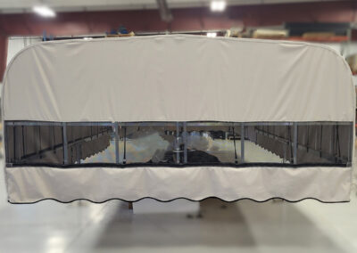 Studio shot of a clean tan vinyl boat lift canopy replacement top featuring a classic scalloped valance skirt edge line.