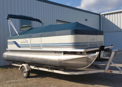 Gray pontoon boat cover with a teal accent band along the top border.