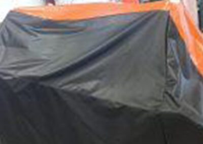 Custom fitted tractor cover with orange accent stripe detailing