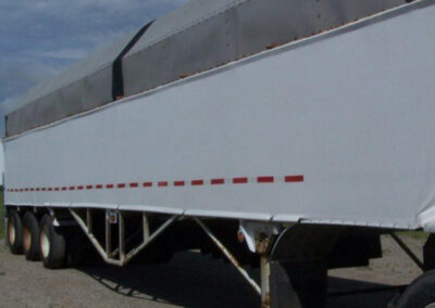 White vinyl wind tamer panel installed along a trailer side
