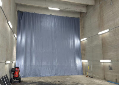 Ceiling-mounted curtain enclosure installed in a wash bay area
